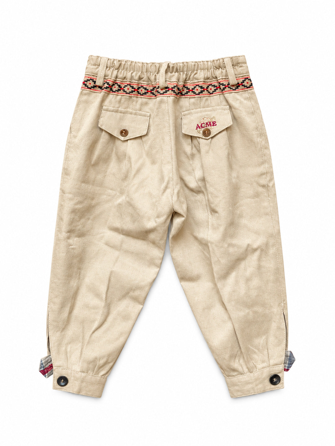 Back view of a pair of beige corduroy pants for toddlers, featuring an elastic waistband with a colorful geometric pattern, flap pockets, and buttoned cuffs. Argentine Bombacha Pants, horseback riding, traditional gaucho, Argentine cowboy attire. Soft and breathable fabrics, perfect pants for all-day wear. With a loose fit and elasticated waistband, they allow for plenty of movement, while the high waist provides extra coverage. Everyday look, perfect for both urban and countryside adventures. Cotton Cordur