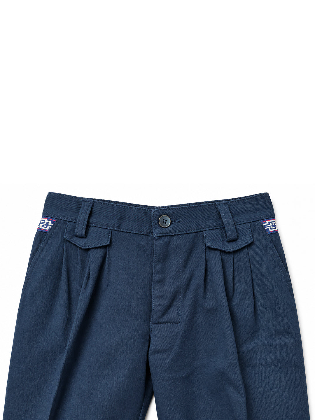 Close-up of the waistband of dark navy blue pleated trousers, showing belt loops, a button closure, and embroidered logo details on the side pockets against a white background. Argentine Bombacha Pants, horseback riding, traditional gaucho, Argentine cowboy attire. Soft and breathable fabrics, perfect pants for all-day wear. With a loose fit and elasticated waistband, they allow for plenty of movement, while the high waist provides extra coverage. Everyday look, perfect for both urban and countryside advent