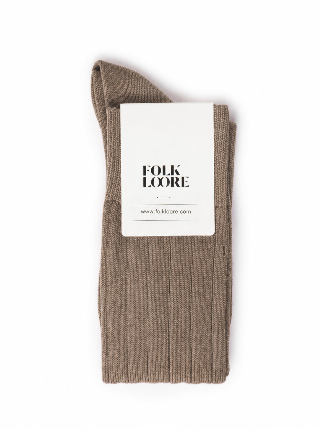 A single ribbed knit sock in taupe-brown, folded with a white paper brand tag that reads 'FOLK LOORE' and 'www.folklore. socks, cotton socks, high-knee socks, made in italy, handmade, artigianally made, fatto a mano, calzettoni invernali, winter cotton, calze di cotone, calze di cachemire, cachemire socks, cashmire socks
